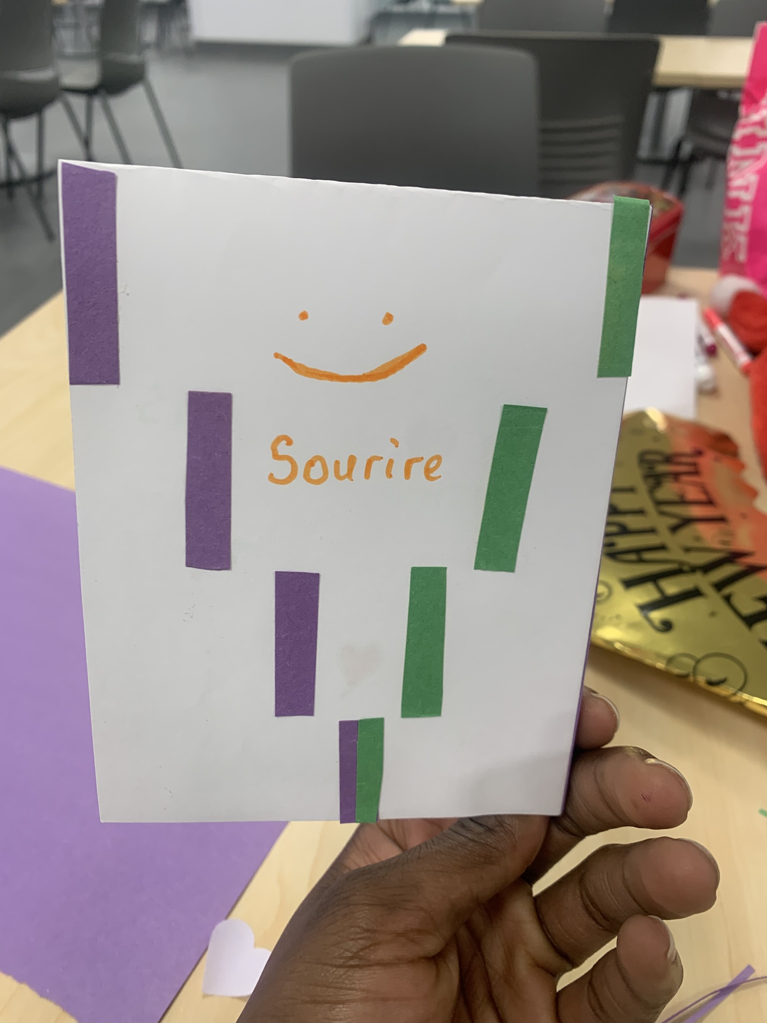 Table covered with colorful handmade cards including messages like 'Bonne année 2026' and 'C'est important'